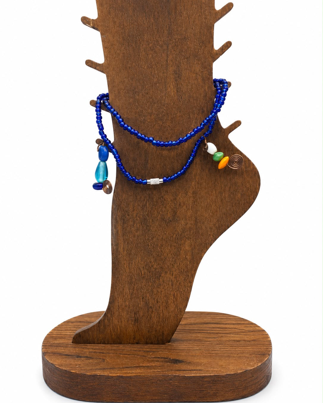 Wooden jewelry stand with a blue beaded bracelet on a white background