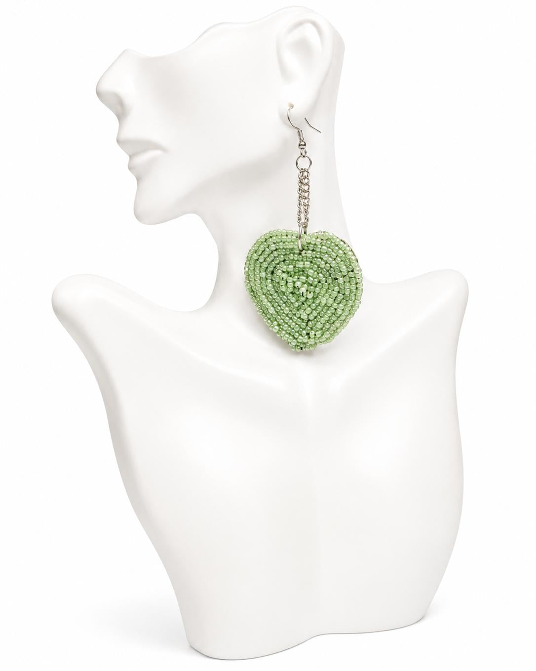 Green heart-shaped beaded earrings on a white mannequin bust.