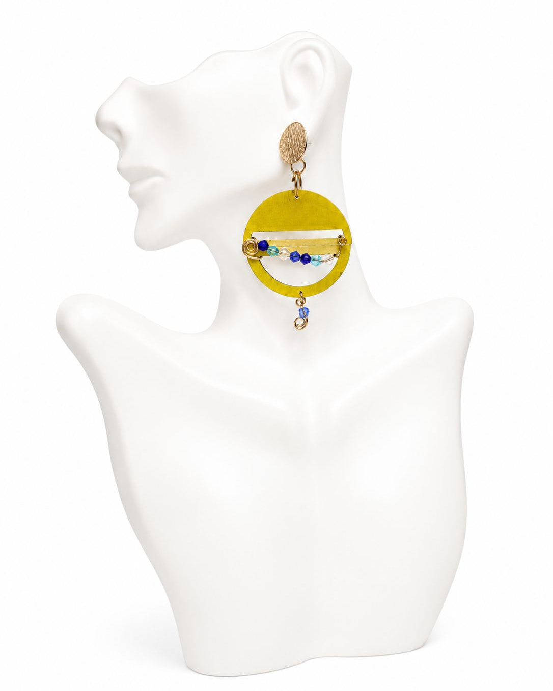 Yellow circular earring on a white mannequin bust