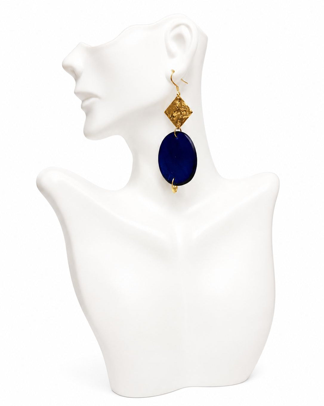 Earring with blue stone and gold accents on a white mannequin bust